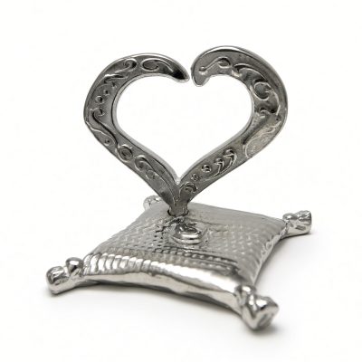 Open heart ring holder in solid pewter on a tasseled pillow base, white background