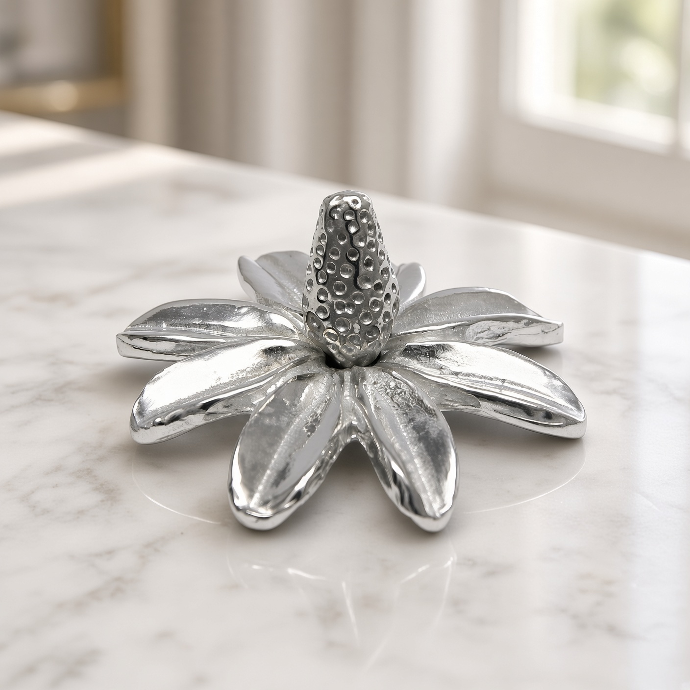 Pewter daisy ring holder on marble by a window
