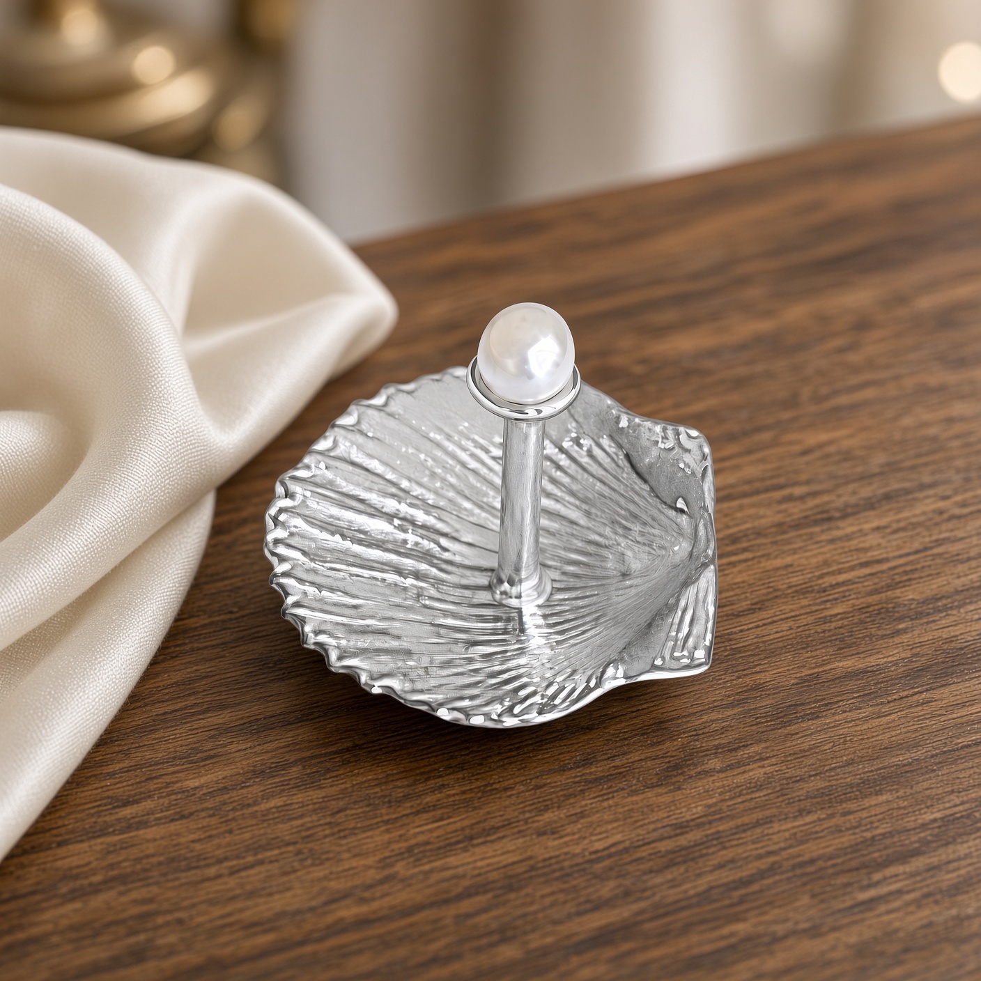 Pewter pearl and shell ring holder on walnut with cream fabric