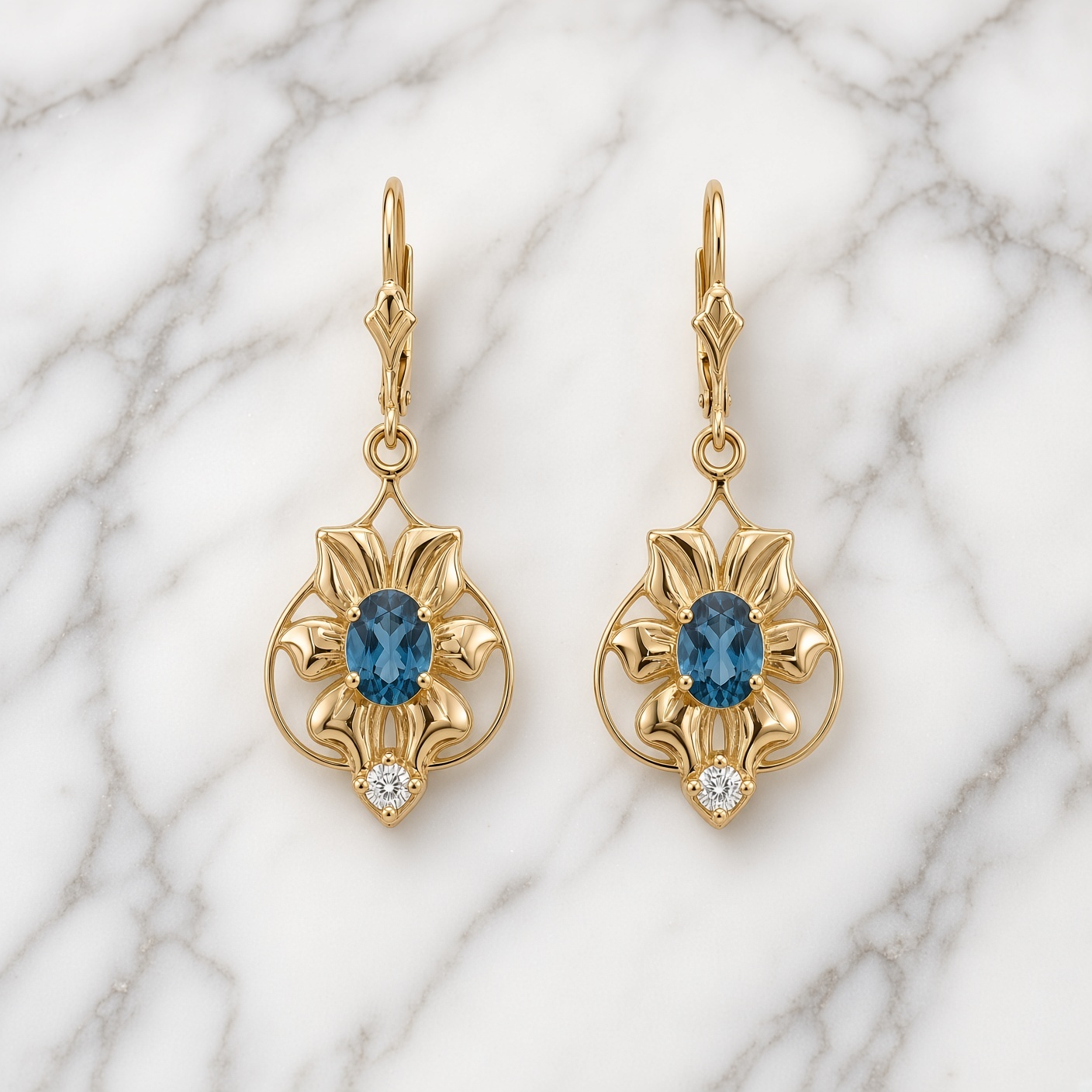 14K gold London blue topaz and diamond flower drop earrings on white marble with gray veining