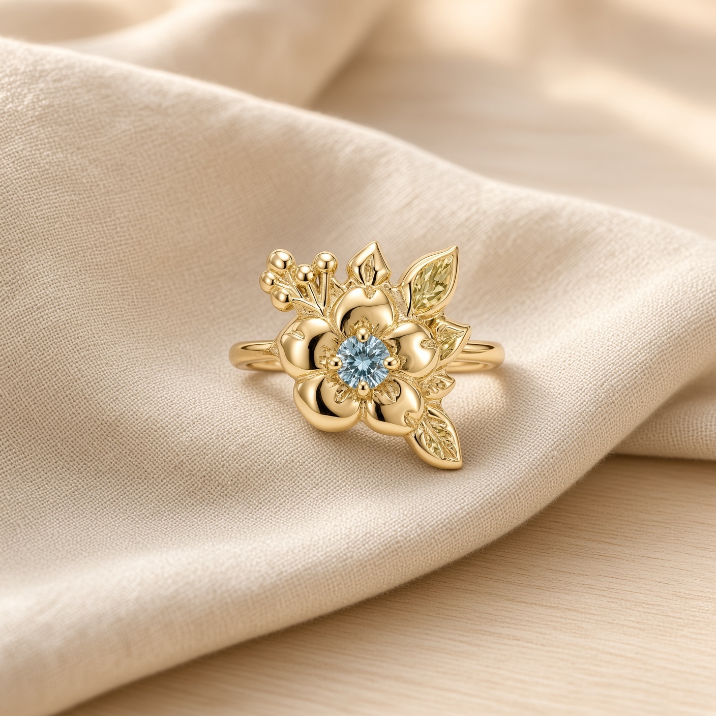 14K yellow gold wild rose ring with a round blue diamond center, sculpted leaves, and gold berries, on soft cream linen