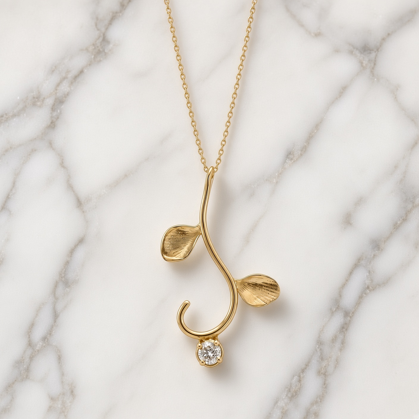 14K gold vine necklace with a single diamond on white and gray marble