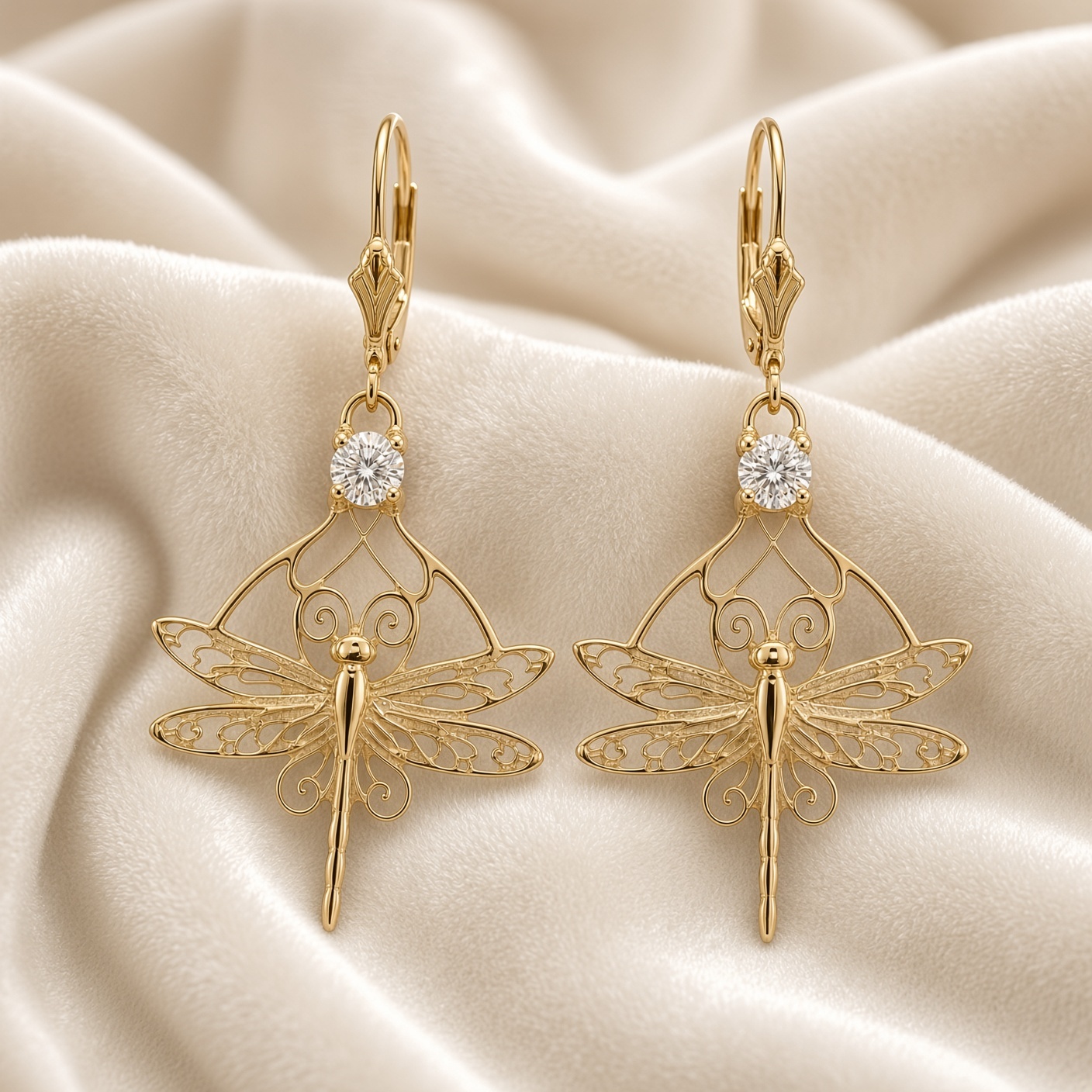 14K gold dragonfly lever back earrings with diamond accents on folds of cream silk