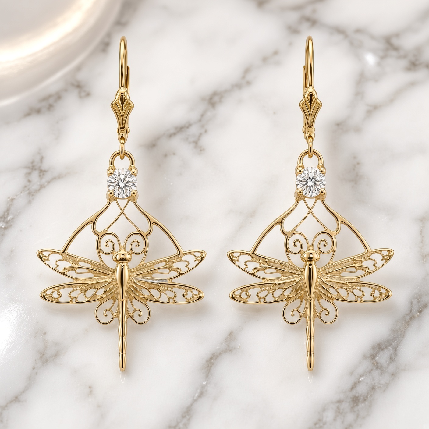 14K yellow gold Nouveau Dragonfly earrings with round diamonds on white marble
