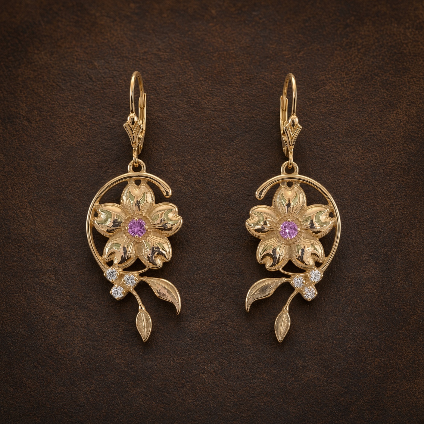 Gold cherry blossom earrings with pink sapphires and diamonds on dark brown leather