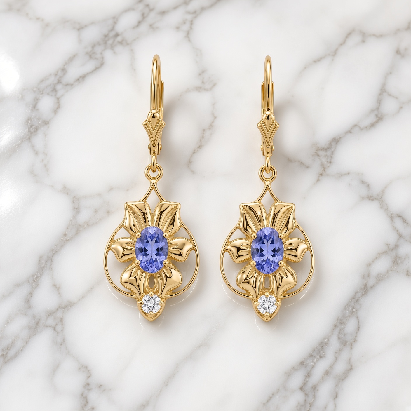 14K gold tanzanite and diamond flower drop earrings on white marble with gray veining